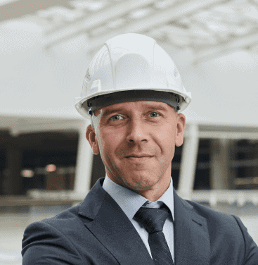 Professional engineer wearing safety helmet at construction site, showcasing expertise in concrete and construction services.