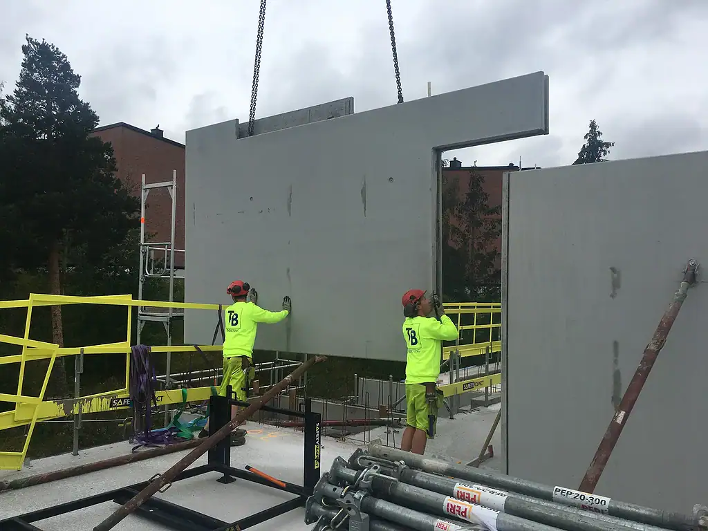 Precast concrete wall panel installation at construction site by Trio Betong, quality construction materials, expert onsite workers.