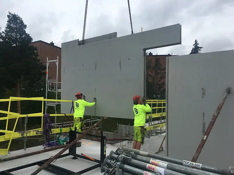 Precast concrete wall panel installation at construction site by Trio Betong, quality construction materials, expert onsite workers.