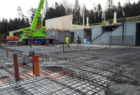 Heavy construction site with rebar reinforcement and concrete pour underway for building foundation by Trio Betong.